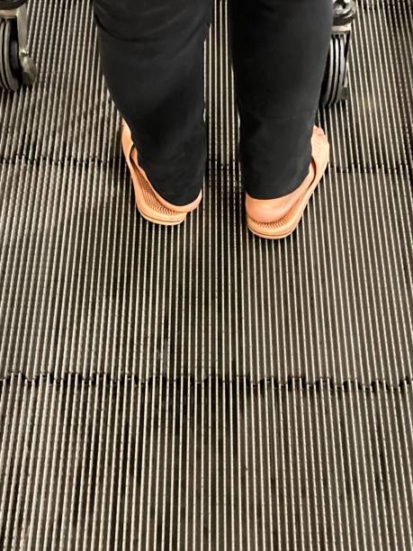 istock feet of people standing on escalators 1350626985