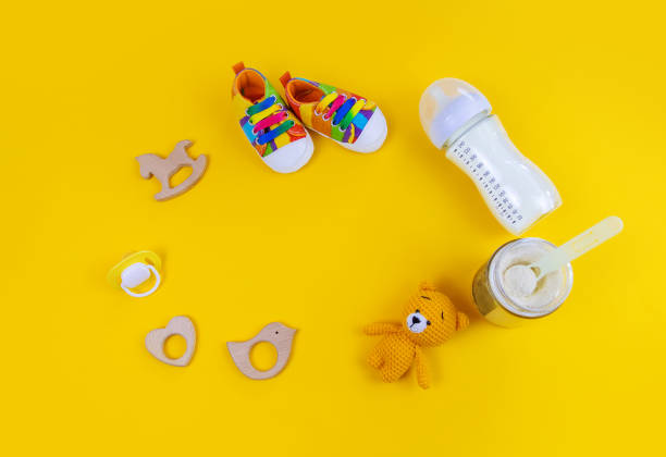 istock Baby milk and accessories on a yellow background. Selective focus. 1350630682