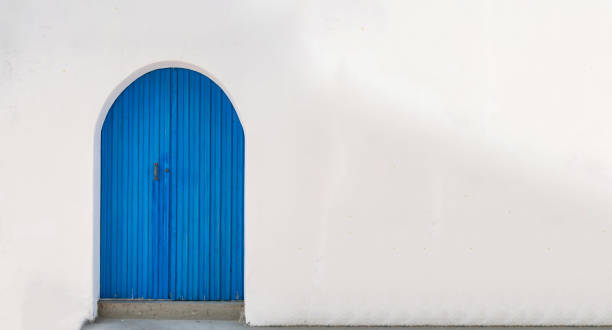Blue wooden door on whitewashed wall background. Copy space card template advertise.