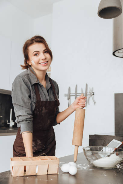 istock Pretty woman standing in kitchen and cooking 1350633859