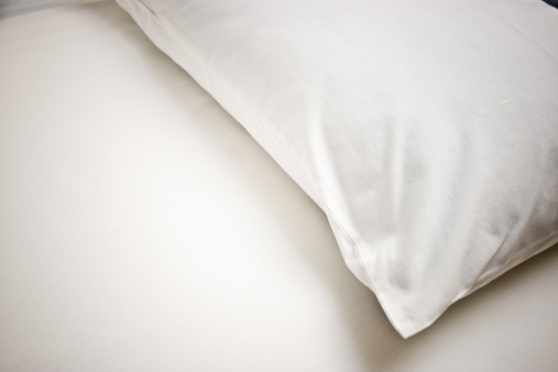 White pillow and white bedsheet.