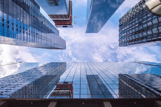 istock Looking up on modern office skyscrapers during perfect day, clouds composed with afternoon sun 1350634699