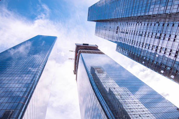 istock Looking up on modern office skyscrapers during perfect day, clouds composed with afternoon sun 1350634841