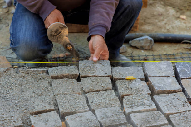 istock Close-up of construction worker installing and laying stones on road sidewalk 1350635629