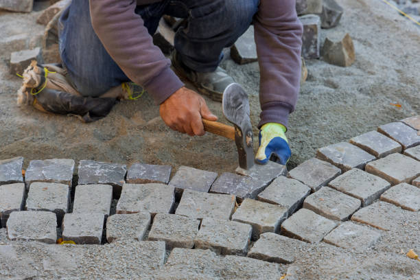 istock Paving pavement with granite stones, workers using industrial cobblestones for paving road 1350635637