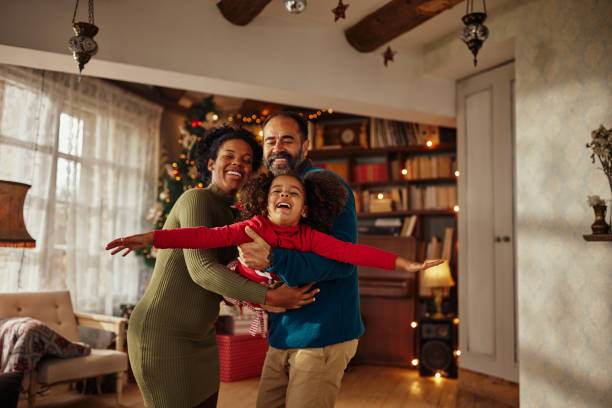 gemischtrassige familie feiert weihnachten und spaßt zu hause - 3 4 months stock-fotos und bilder