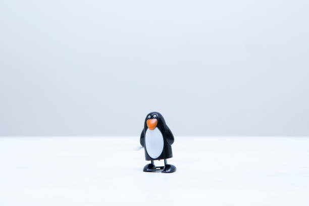 istock Single wind-up penguin toy with copy space above 1350639140