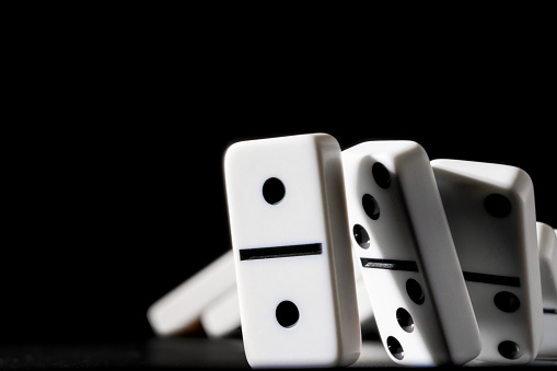 Dominoes standing in a row on black background