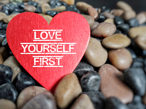 Love yourself first text in vintage background. Stock photo.