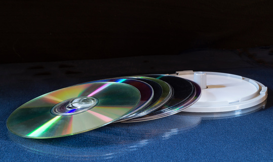 A stack of DVDs on a table with a reflection. Objects on a black background