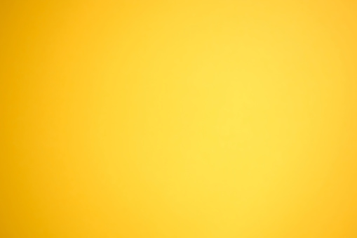 Orange background with a gradient to yellow. Orange paper top view. Abstract bright background without texture.