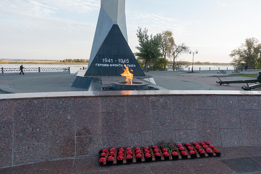 Engels, Russia. October 13, 2021 The eternal flame at the obelisk on the Volga embankment in Engels. Text translation -Heroes of the front and rear