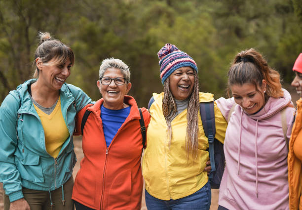mujeres multirraciales felices divirtiéndose abrazándose en el día de trekking al aire libre - estilo de vida saludable y concepto de amistad multigeneracional - fun walk fotos fotografías e imágenes de stock