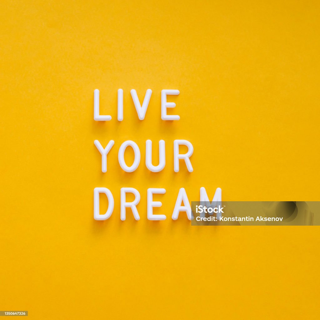Live your dream. Motivating and inspiring phrase on bright yellow background. Top view on lifting spirit message. Creative rise. Exhilaration Stock Photo