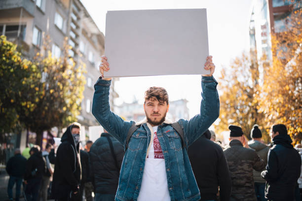 uomo in protesta con in mano un poster vuoto. - protestor foto e immagini stock