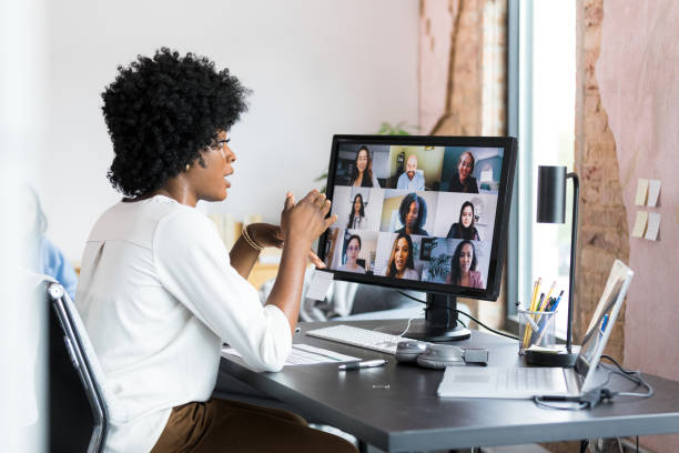 istock Female team lead gestures while presenting to co-workers via teleconferencing 1350649347