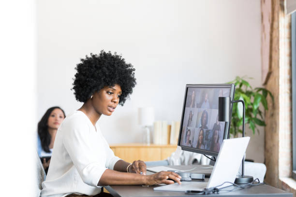istock Woman uses laptop while leading meeting with co-workers on desktop 1350649348