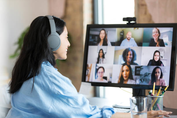 istock Female student with headphones smiles as she joins virtual class 1350649364