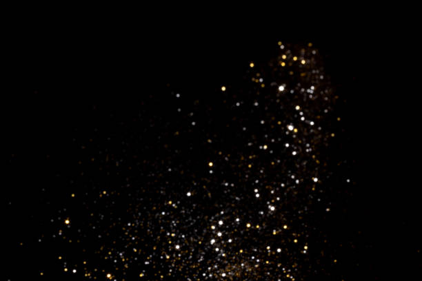 istock Golden and silver blurred bokeh lights on black background 1350650513