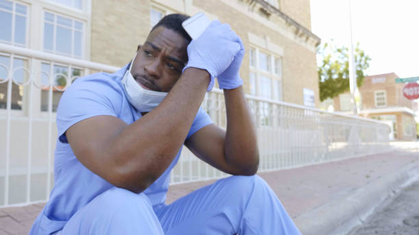 Male nurse or doctor sits on curb after difficult shift