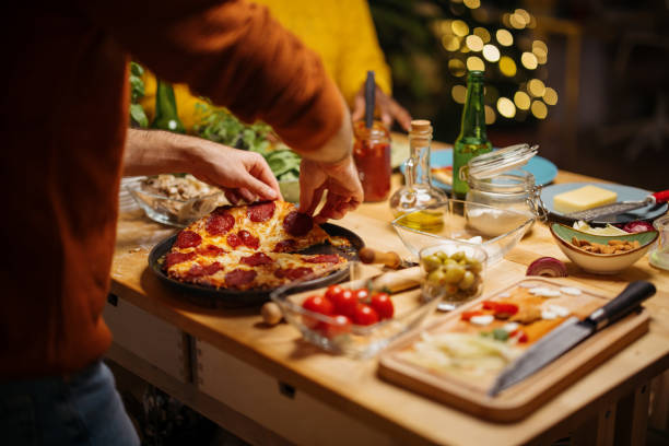 istock Man slicing homemade pepperoni pizza 1350651443