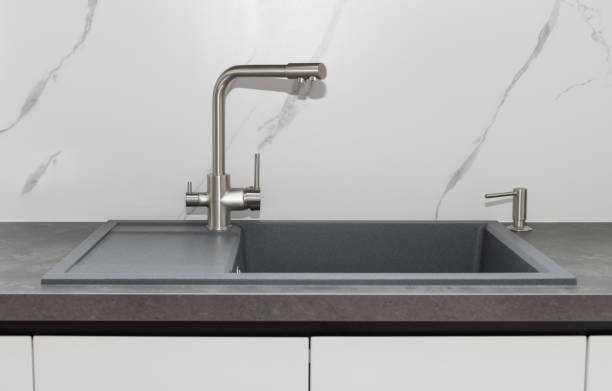 istock Gray kitchen sink with silver tap and integrated detergent dispenser 1350651883
