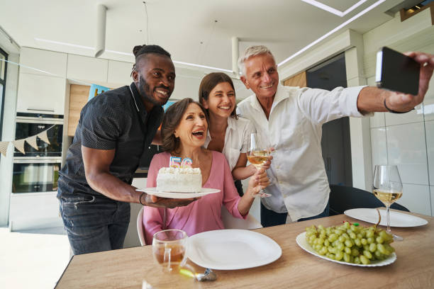 istock Smiling man holding smartphone and hugging family 1350653383