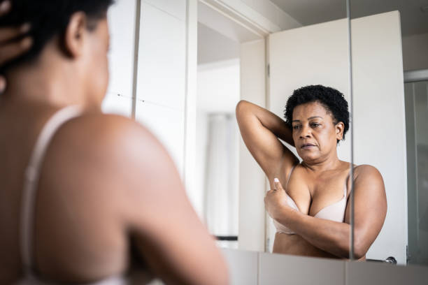 istock Mature woman doing self breast exam at home 1350655368