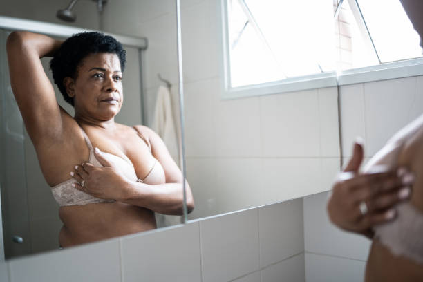 istock Mature woman doing self breast exam at home 1350655370