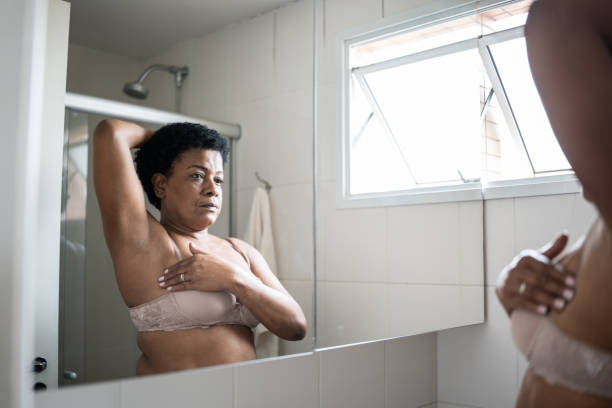 istock Mature woman doing self breast exam at home 1350655372