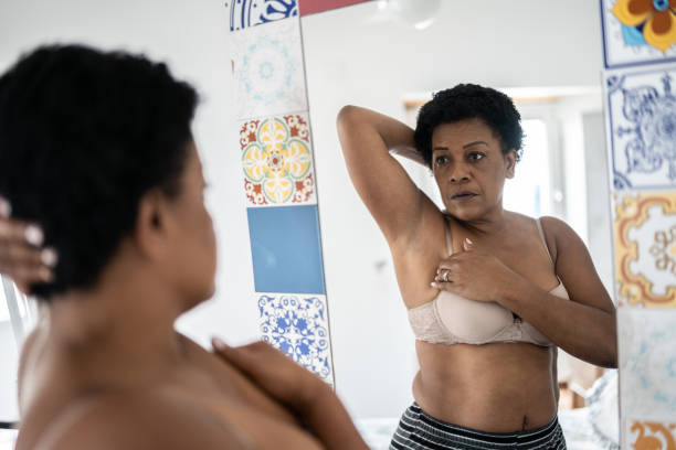 istock Mature woman doing self breast exam at home 1350655602
