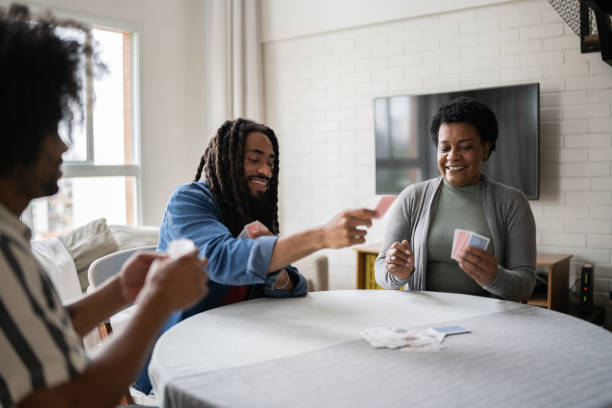 istock Mother and sons playing cards at home 1350657624