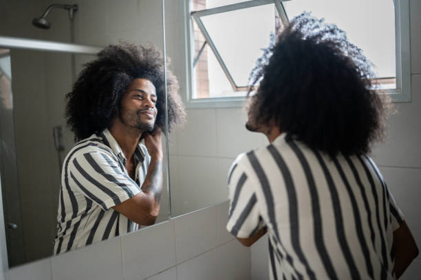 young man admiring himself in the mirror - look into the mirror imagens e fotografias de stock