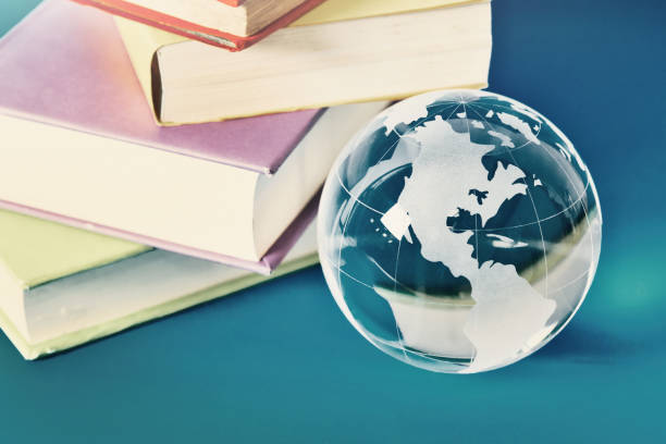 istock World of knowledge: crystal glass globe with stack of books 1350657637