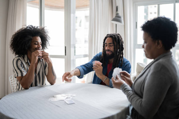 istock Mother and sons playing cards at home 1350657683