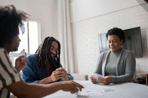 istock Mother and sons playing cards at home 1350657767