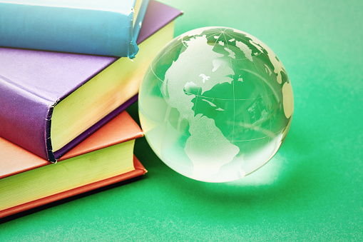 Glass world globe with a group of books.