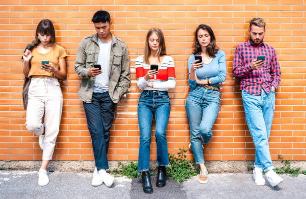 istock Multicultural people group using smartphone at university college backyard - Milenial friends addicted by mobile smart phone - Technology concept with always connected students - Warm vivid filter 1350660140