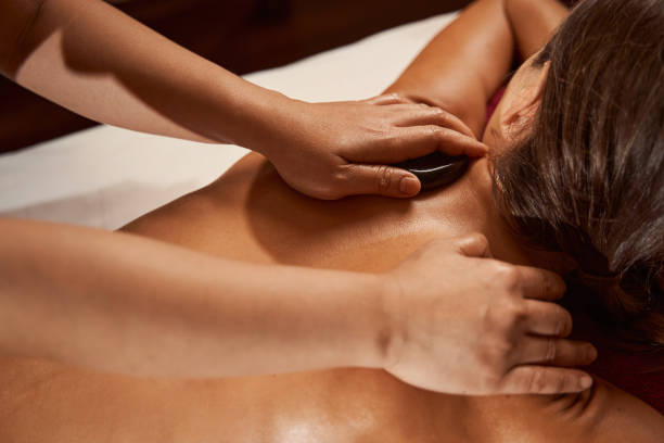 istock Wellness center client receiving hot stone massage 1350660490