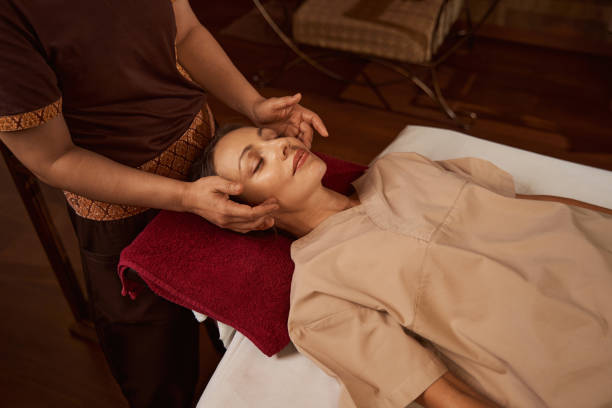istock Professional masseuse massaging acupressure points on client face 1350660550