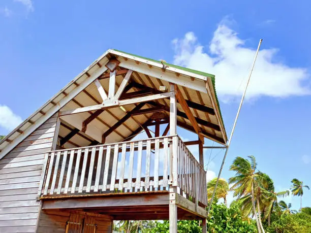 Side view Caribbean wood construction with its island-style architecture with a high ceiling and wooden facade. Urbanism and tropical colonial architecture. Wooden guardhouse on the beach.