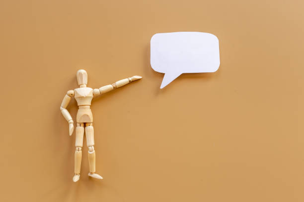 istock Wooden man figure presenting and showing on speech bubble banner 1350663756