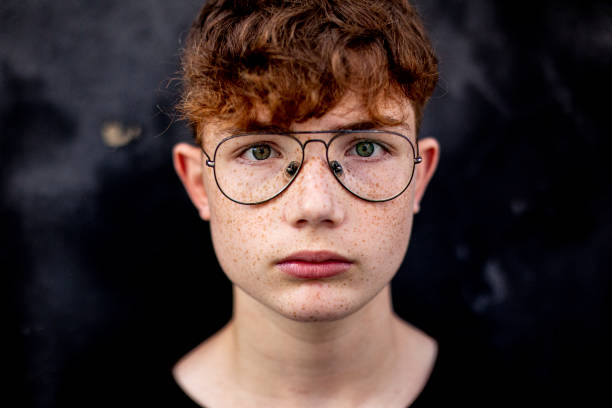 portrait d’un adolescent aux cheveux roux avec des taches de rousseur et des lunettes - teenage boys teenager teenagers only adolescence photos et images de collection