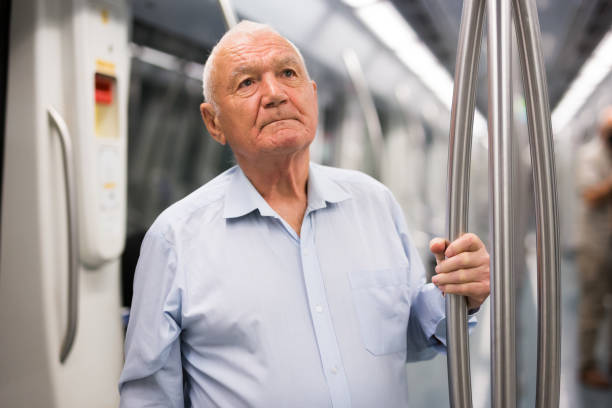 istock Old man standing in subway car 1350665141