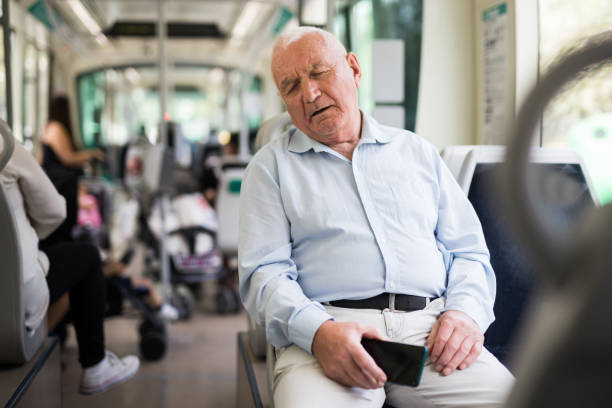 Elderly man sitting in tram and sleeping Old European gray haired man sitting in streetcar and sleeping. sleeping grandpa stock pictures, royalty-free photos & images
