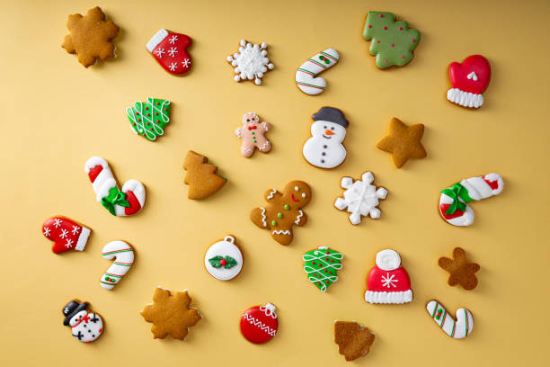 Assorted Christmas gingerbread cookies on golden surface, holiday concept stock photo