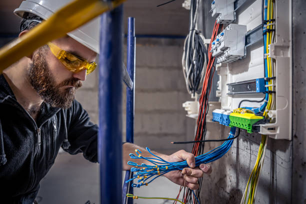 istock A male electrician works in a switchboard with an electrical connecting cable. 1350671032