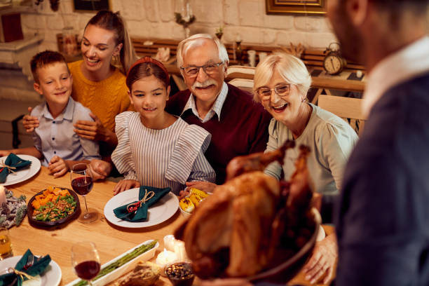 istock Happy multi-generation family having Thanksgiving turkey for dinner at dining table. 1350671460