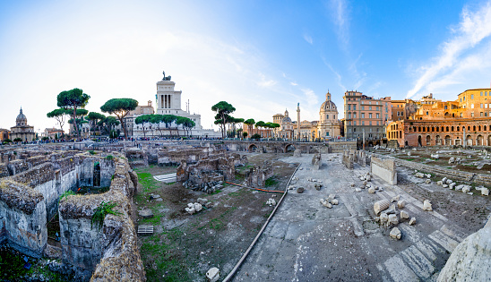 Rome, Lazio, Italy - October 30, 2021: Via dei Fori Imperiali is one of the most scenic streets in Rome; opened in 1932 with the name of via dell'Impero, it takes its current name from the monumental remains of the forums of Caesar, Augustus, Nerva, della Pace and Traiano that can be admired by walking along it. In the background the Church of Santa Maria di Loreto and the Trajan column