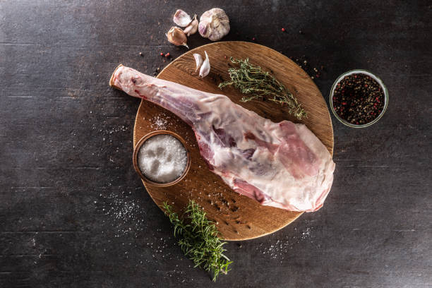 Raw lamb leg with spices, salt, herbs and garlic - top of view. Raw lamb leg with spices, salt, herbs and garlic - top of view. Lamb stock pictures, royalty-free photos & images